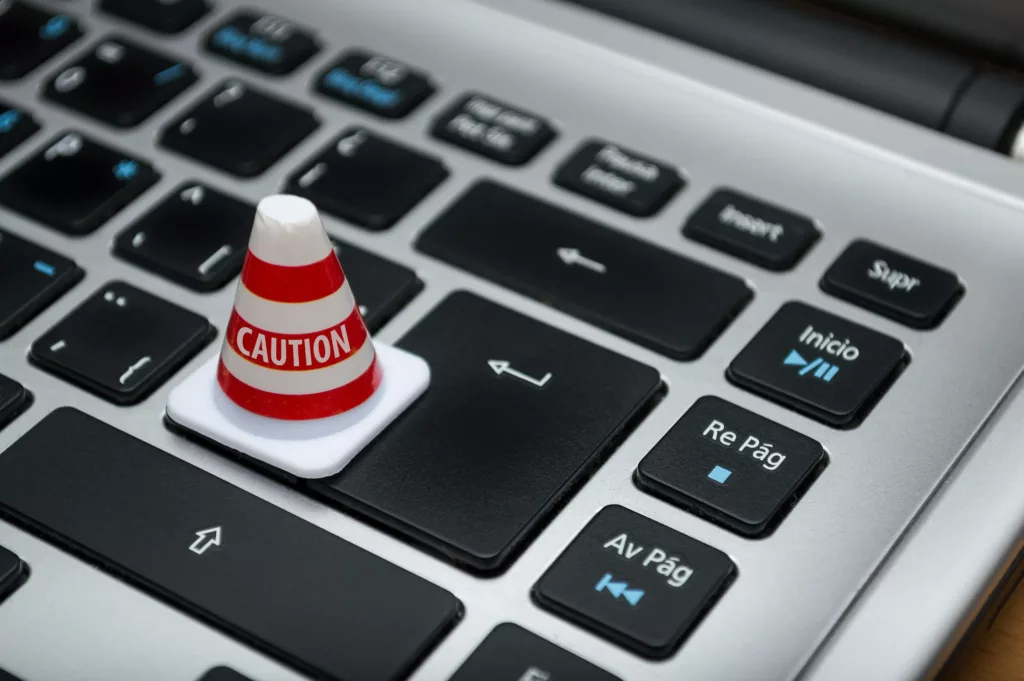 A pawn with caution written on it standing on the computer